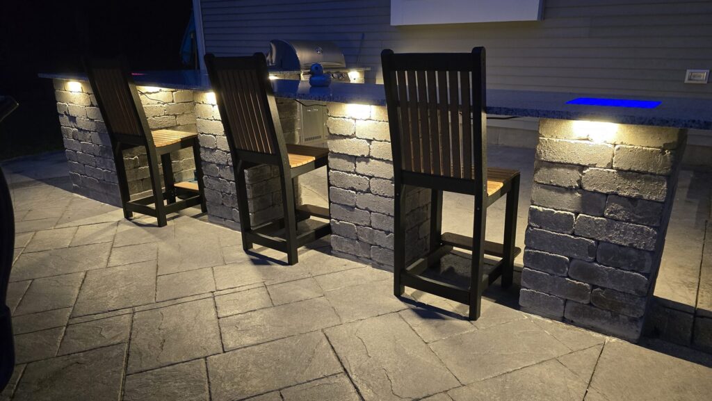 Illuminated outdoor kitchen and bar seating in Halifax Massachusetts
