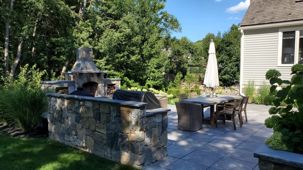 Outdoor kitchen and fireplace integrated into the Hingham terrace