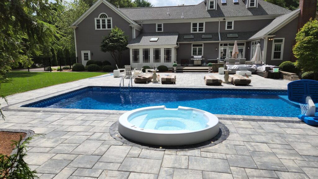 Full Mansfield pool surround viewed across the water toward the home