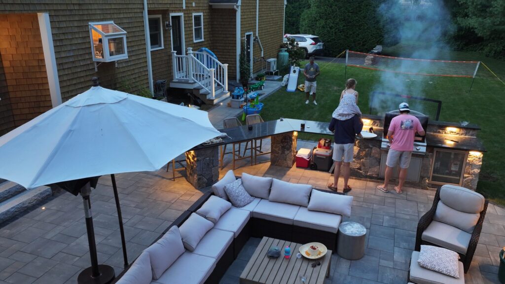 Outdoor kitchen in use beside the furnished Duxbury patio