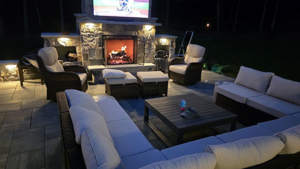 Fireplace and lounge seating illuminated after dark in Duxbury