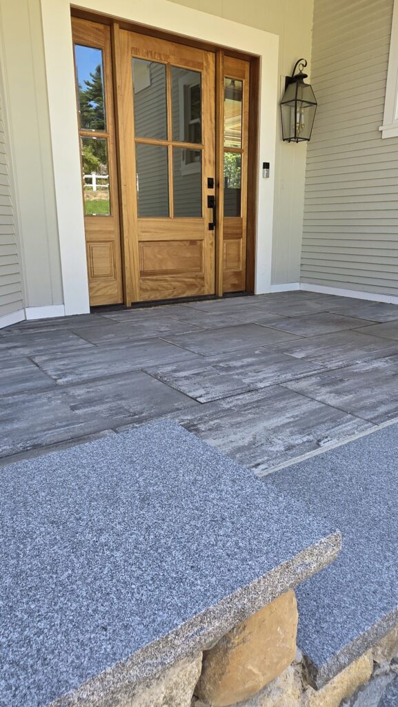 Stone-edged walkway approaching a Norwell home entrance