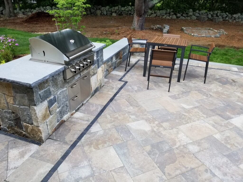 Stone outdoor kitchen and dining area in Easton