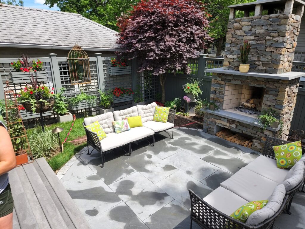 Outdoor seating arranged around a masonry fireplace in Wollaston Quincy