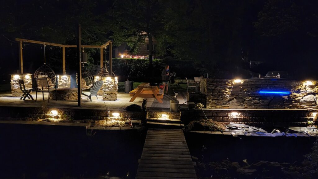 Waterfront outdoor living space illuminated at night
